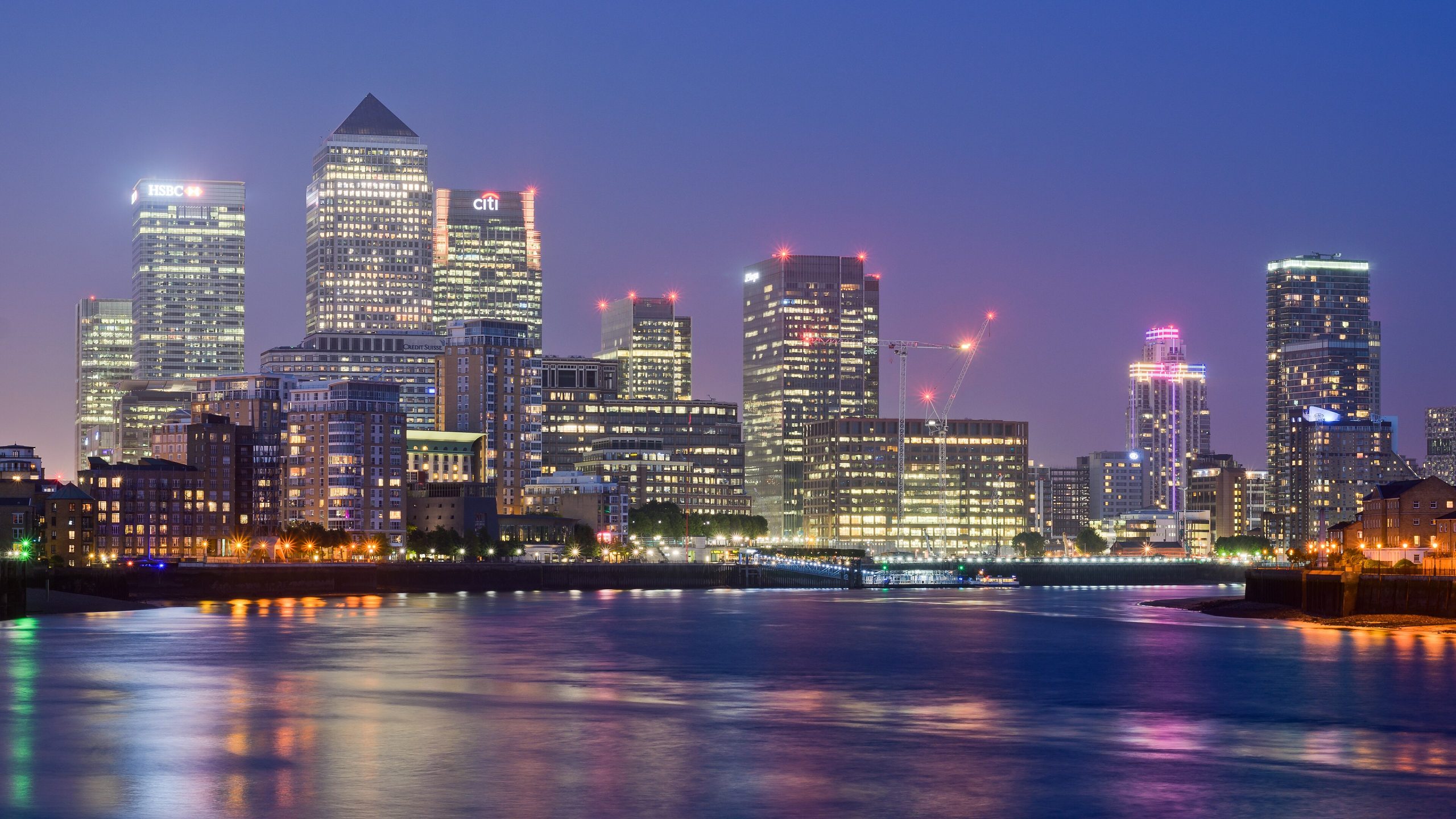 Illuminated Canary Wharf skyscrapers at night viewed from Limehouse, London